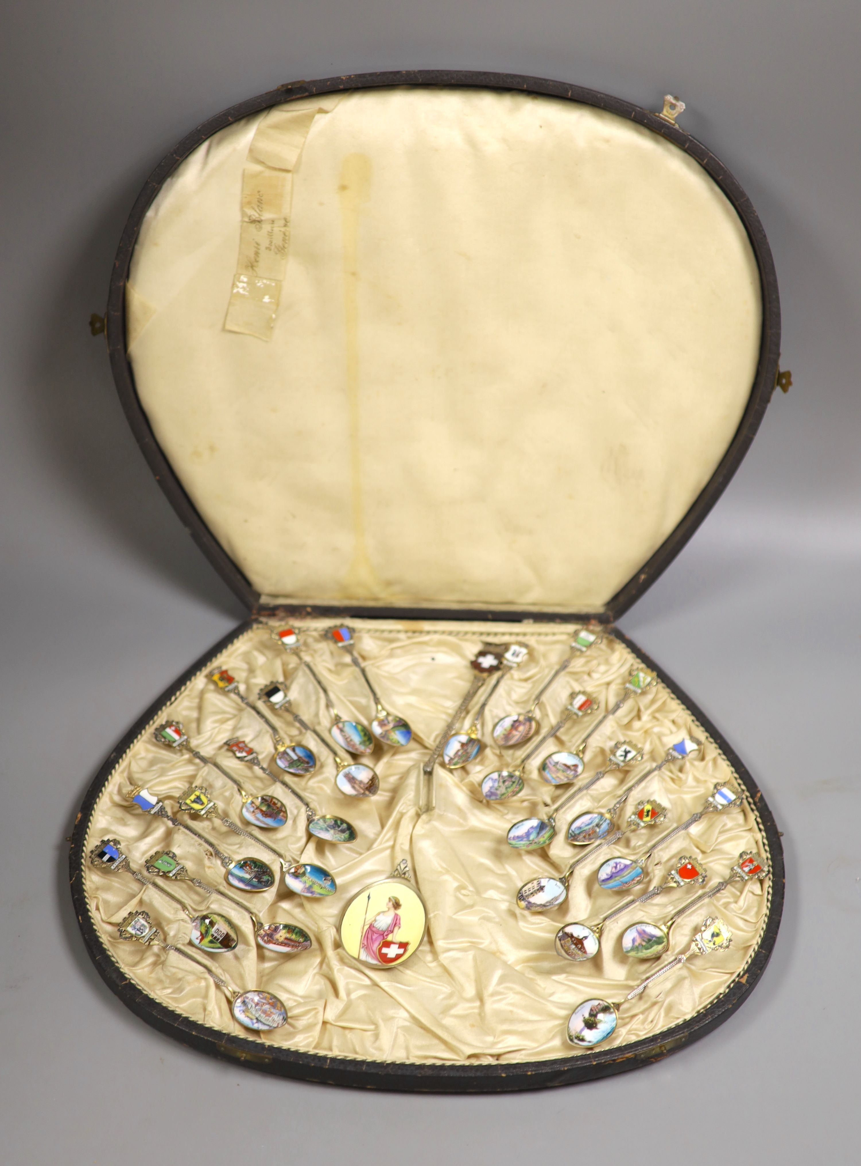 A set of 22 Swiss 800 silver and enamel souvenir spoons, each representative of a Canton, cased, with a larger spoon.